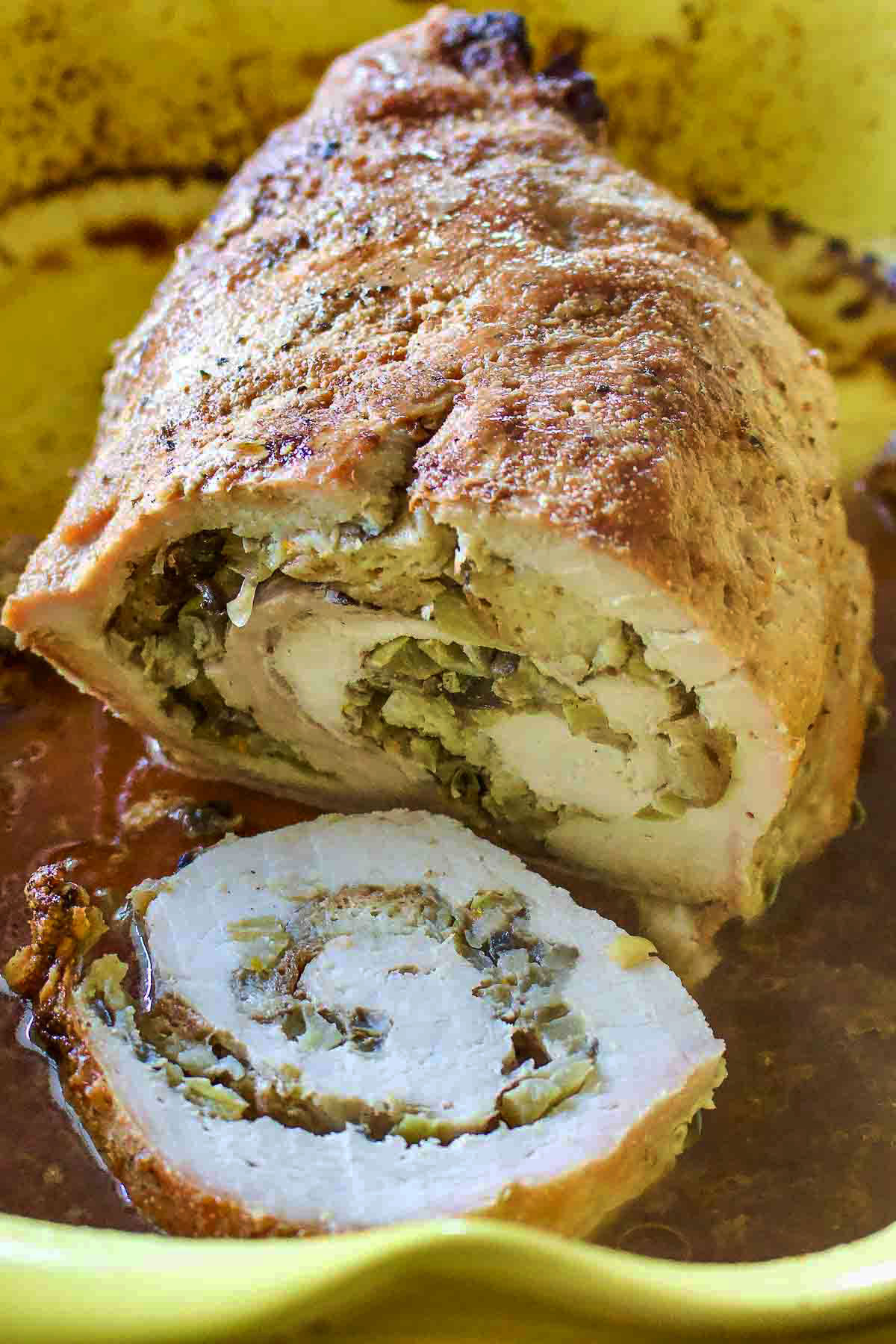 Apple and mushroom stuffed roasted pork tenderloin is a recipe that makes a great alternative for the usual ham around the holidays. Apple And Mushroom Stuffed Roasted Pork Loin in the baking pan.