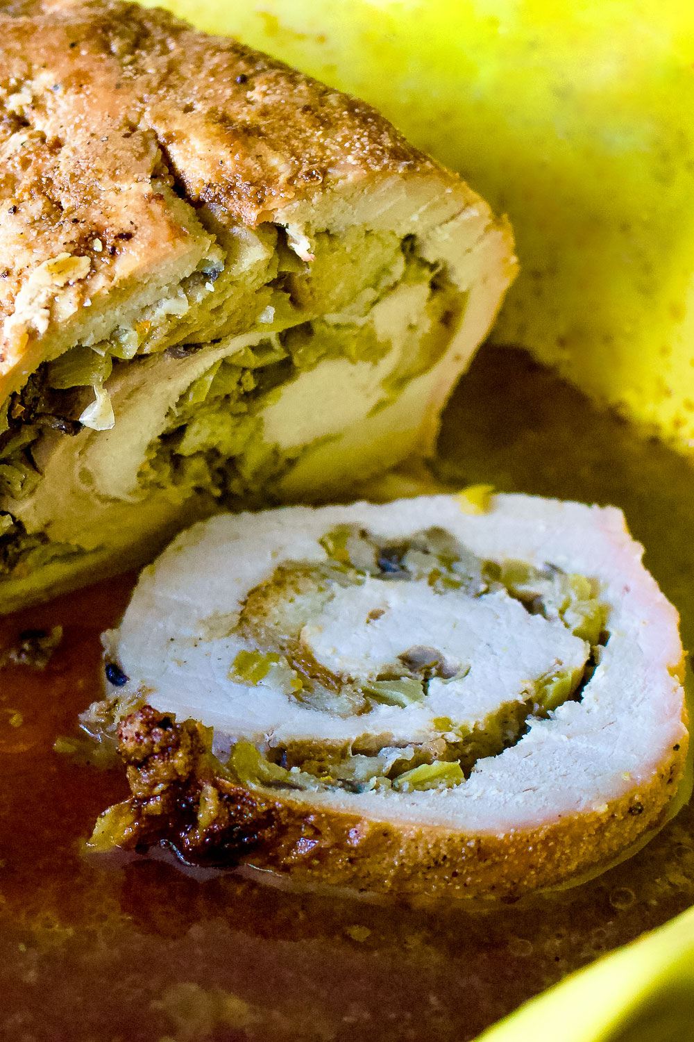 Apple and mushroom stuffed roasted pork tenderloin is a recipe that makes a great alternative for the usual ham around the holidays. Apple And Mushroom Stuffed Roasted Pork Loin vertical photo