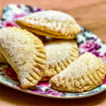 Mini Turnover Cookies With Jam stacked on a colorful plate.
