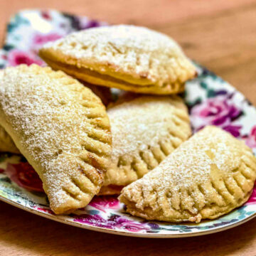 Mini Turnover Cookies With Jam stacked on a colorful plate.