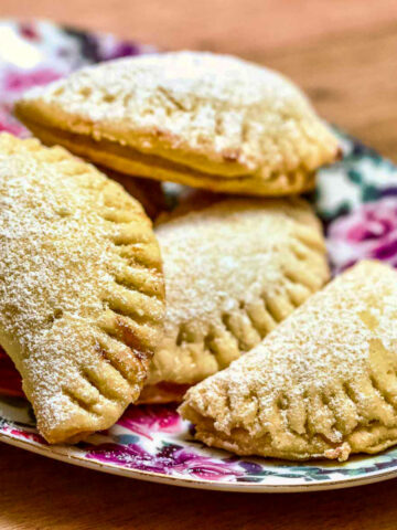 Mini Turnover Cookies With Jam stacked on a colorful plate.