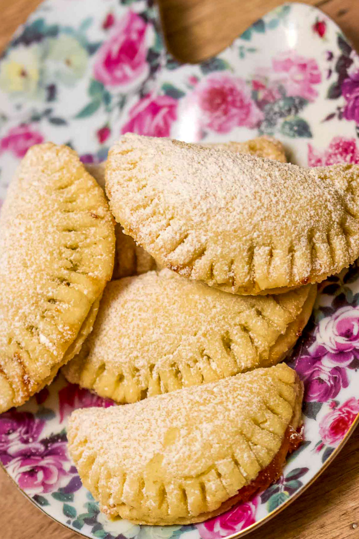 Delicious mini turnover cookies with jam on a decorative plate.