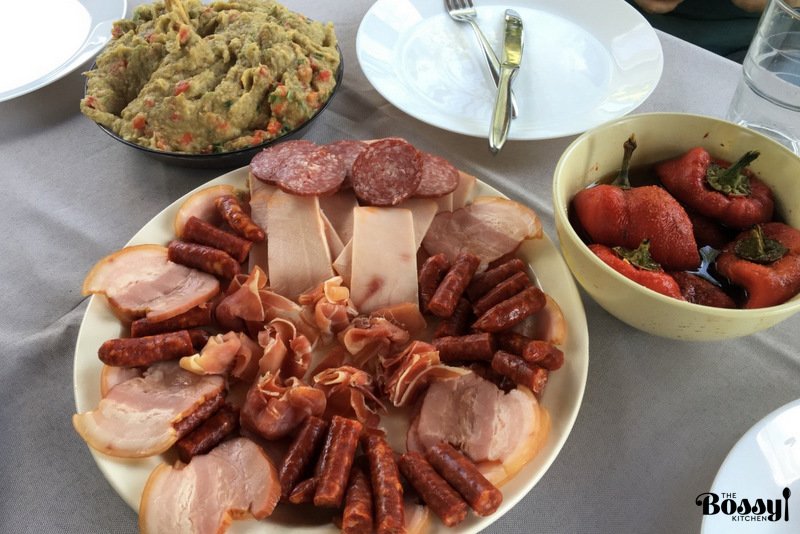 cold cuts on a platter with roasted pepper salad and eggplant spread