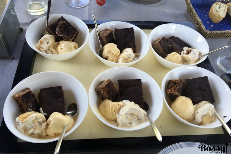 Brownies with tahini served in white bowl with vanilla ice cream
