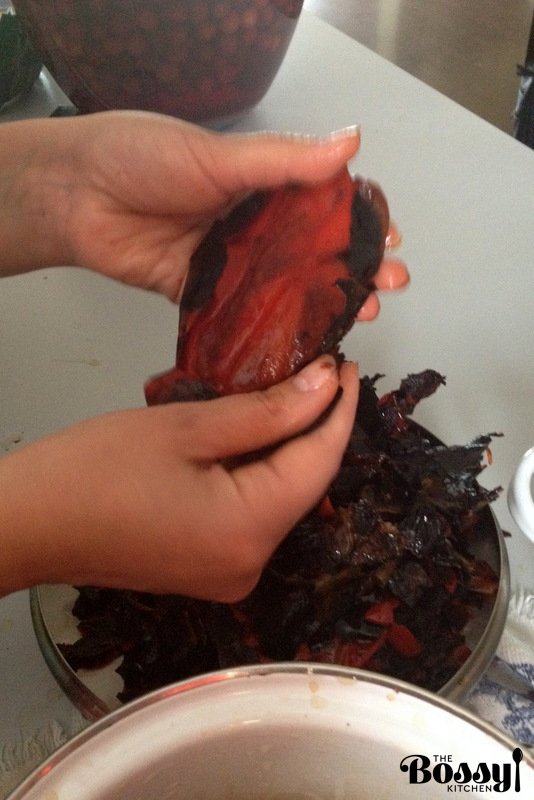 removing the charred skin from the grilled peppers