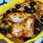 Delicious chicken Marbella in a yellow baking dish.