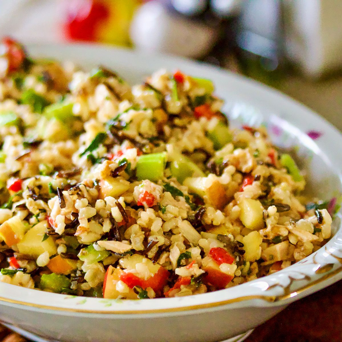 Rice salad with apples and chicken in a serving bowl.