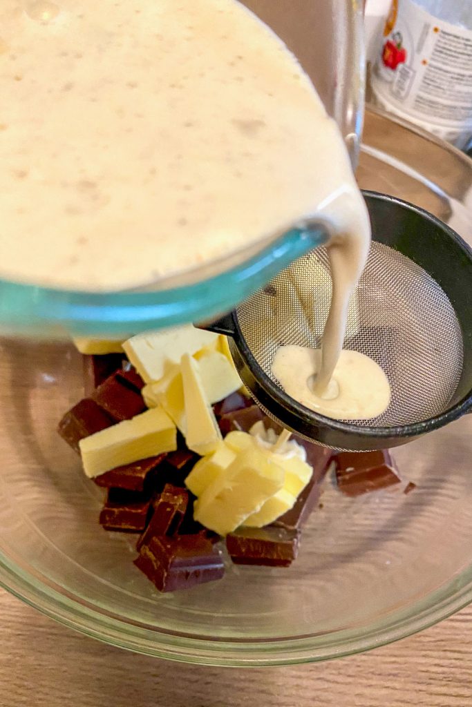 straining the heavy cream over chocolate