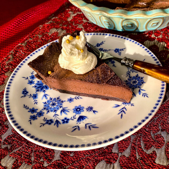 Slice of chocolate tart on blue and white plate-close up square picture