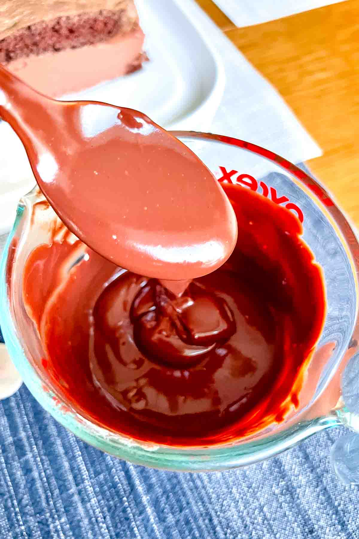 Chocolate Ganache in a measuring bowl with spoon.