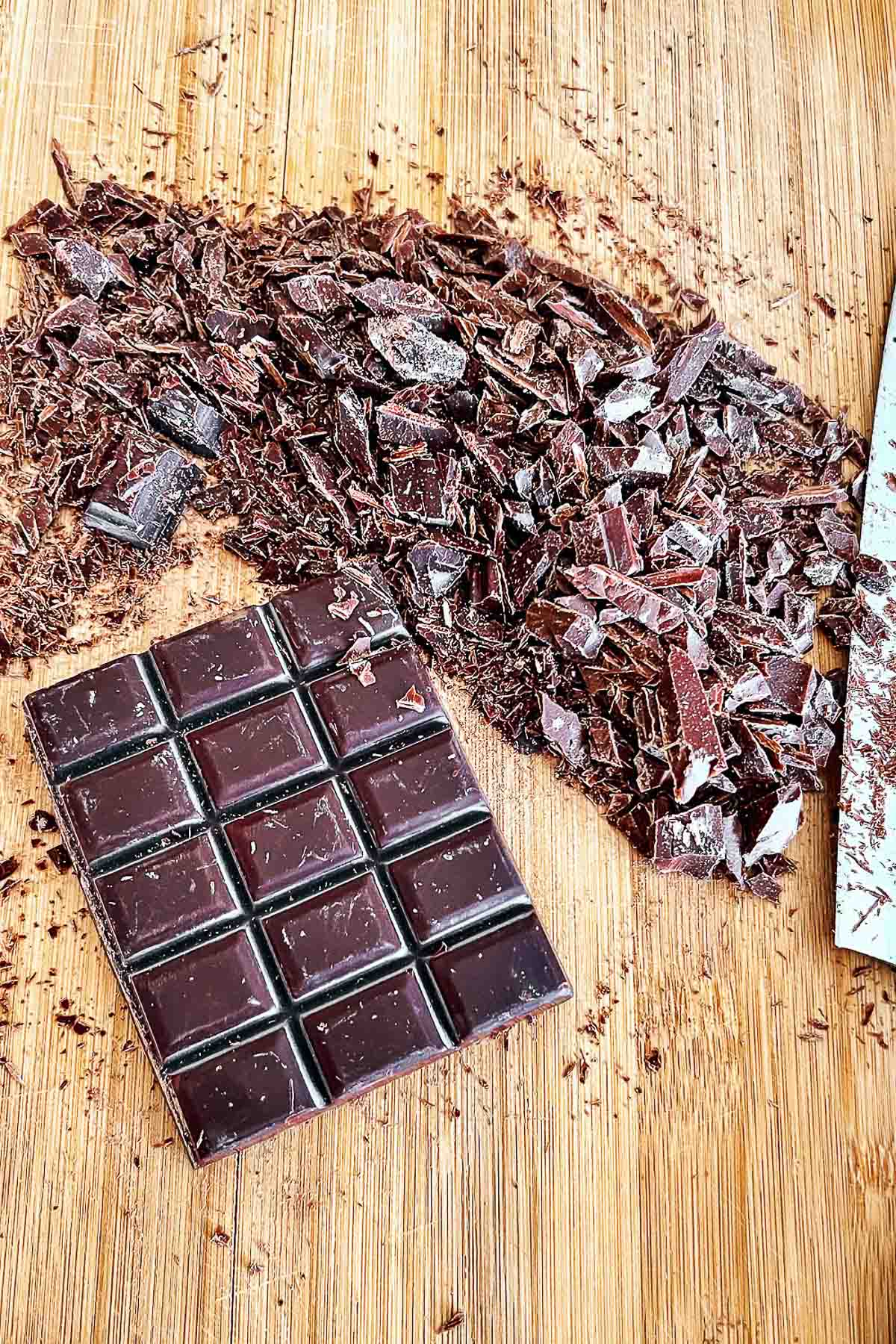 Chopped Dark Chocolate on wooden board.