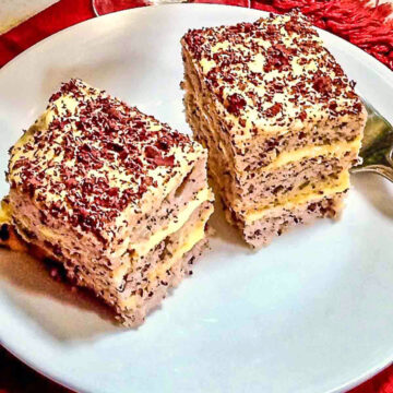 Slices of Almond Dacquoise Cake With Orange Buttercream on white plate.