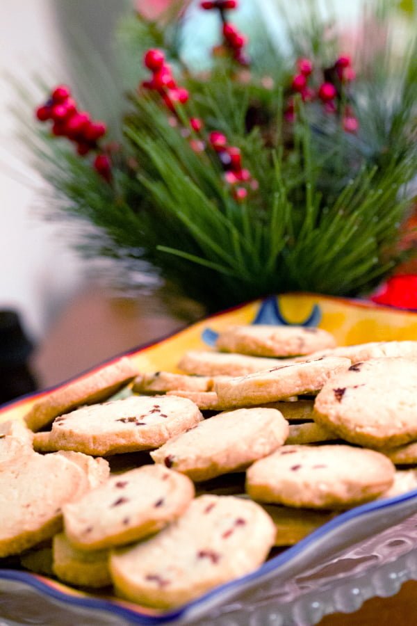 These almond-cranberry shortbread cookies remind us of the holidays. Perfect recipe for potlucks, cookies swap parties and any holiday event. almond-cranberry shortbread cookies on a yellow platter