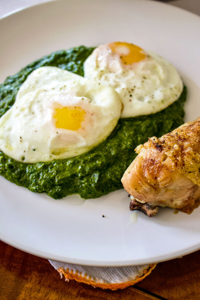 Easy creamed spinach Creamed spinach on plate with fried eggs and chicken meat0