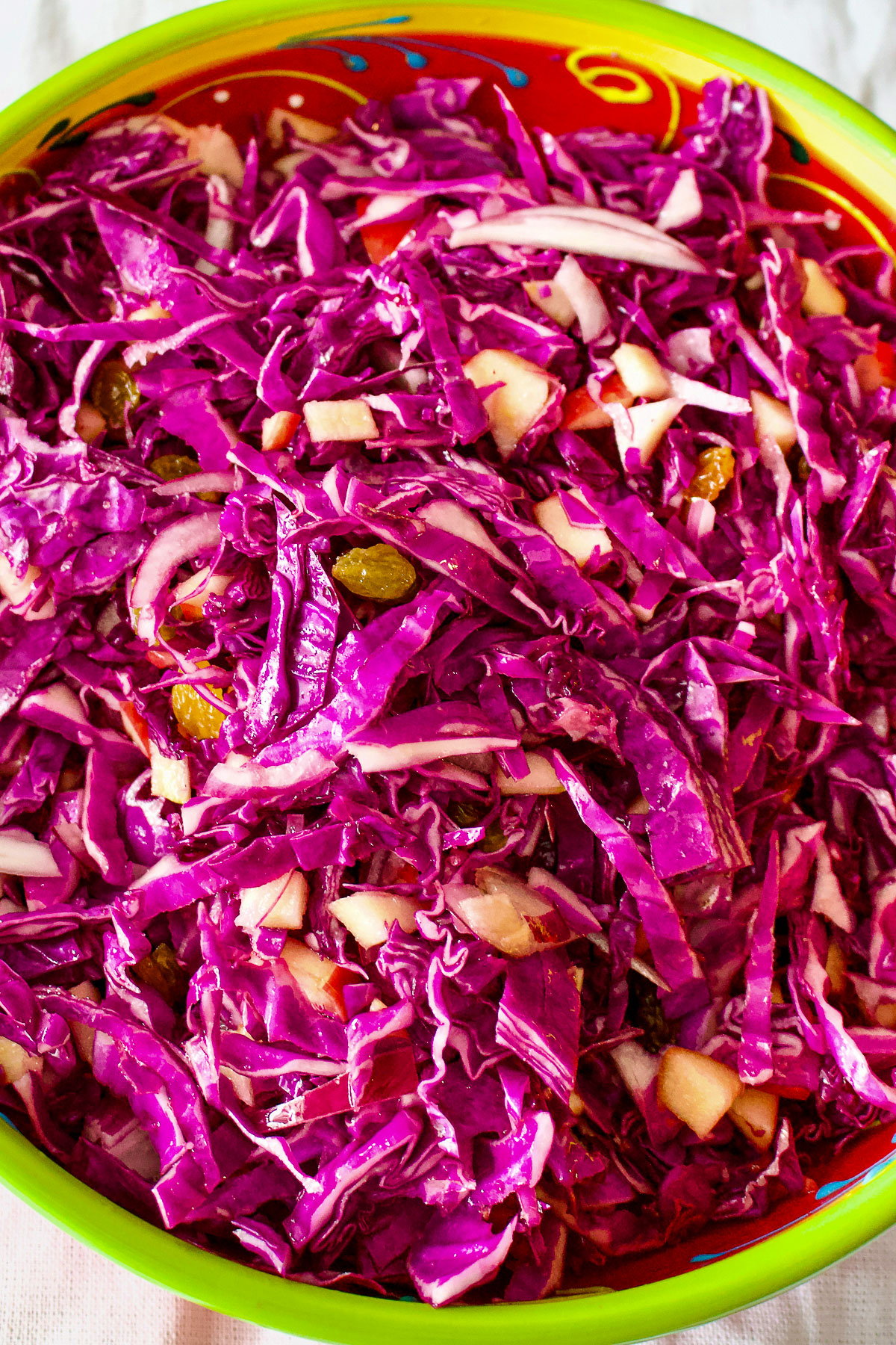 Apple walnuts and raisins red cabbage salad Red cabbage with apples and walnuts in a bowl0