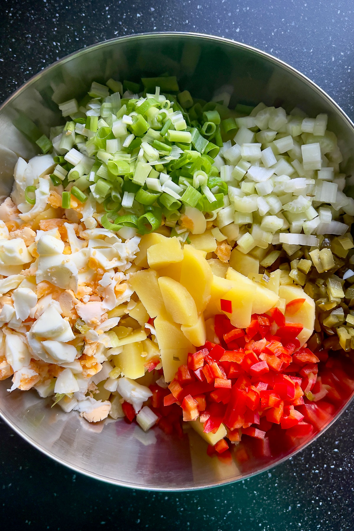 This is a classic, delicious easy American potato salad that can be made all year round. Make it with a day before and serve it chilled. Chopped ingredients in a bowl for potato salad