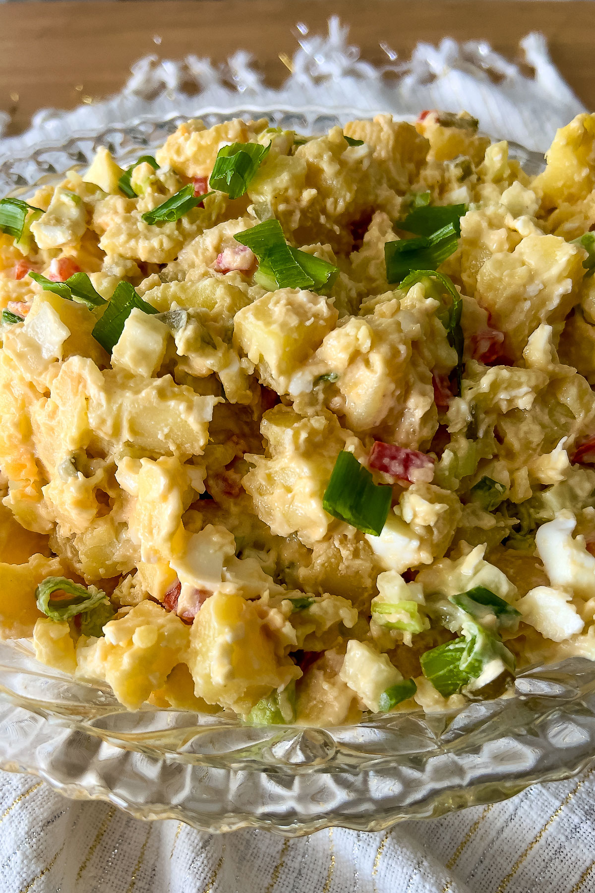 This is a classic, delicious easy American potato salad that can be made all year round. Make it with a day before and serve it chilled. Classic Potato Salad in a glass bowl on a white towel0