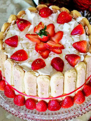 Charlotte Russe Cake with strawberries on a glass cake stand.