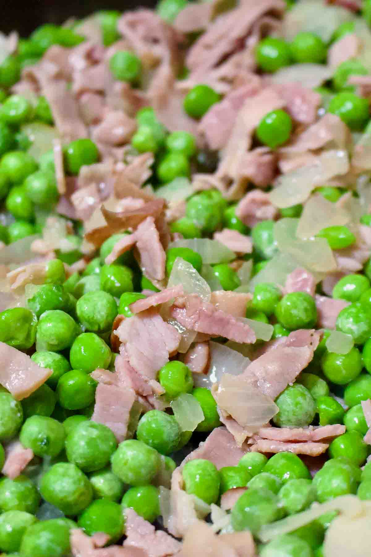 Peas With Ham cooking in a pan.