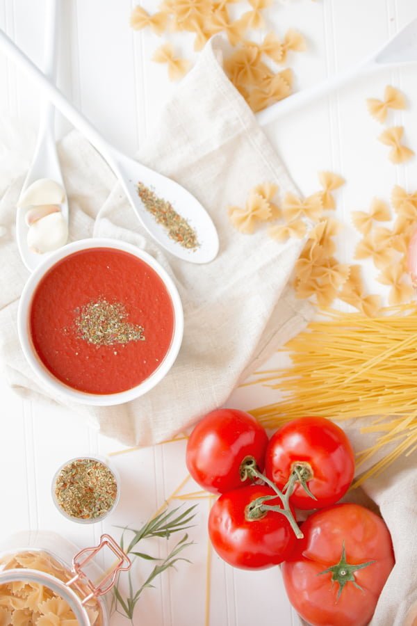Romanian Tomato Soup Dairy Free- on a white table decorated with pasta