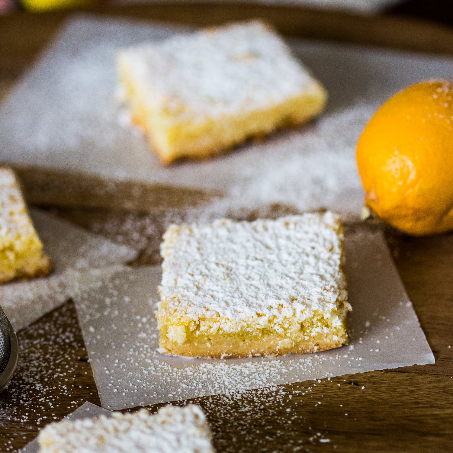 Coconut-Almond Lemon Bars Recipe is a tasty, twisted version of the traditional lemon bars. The combination of coconut, lemon and almond is a perfect one. Coconut-Almond Lemon Bars Recipe on a wooden board dusted with powder sugar