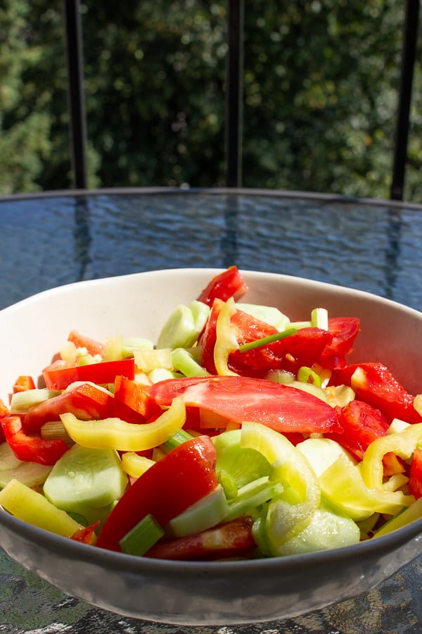 Quick Tomato Cucumber And Pepper Summer Salad is a delicious recipe that uses fresh tomatoes, cucumbers and peppers tossed in vegetable oil and salt. Tomato Cucumber Salad in a white bowl
