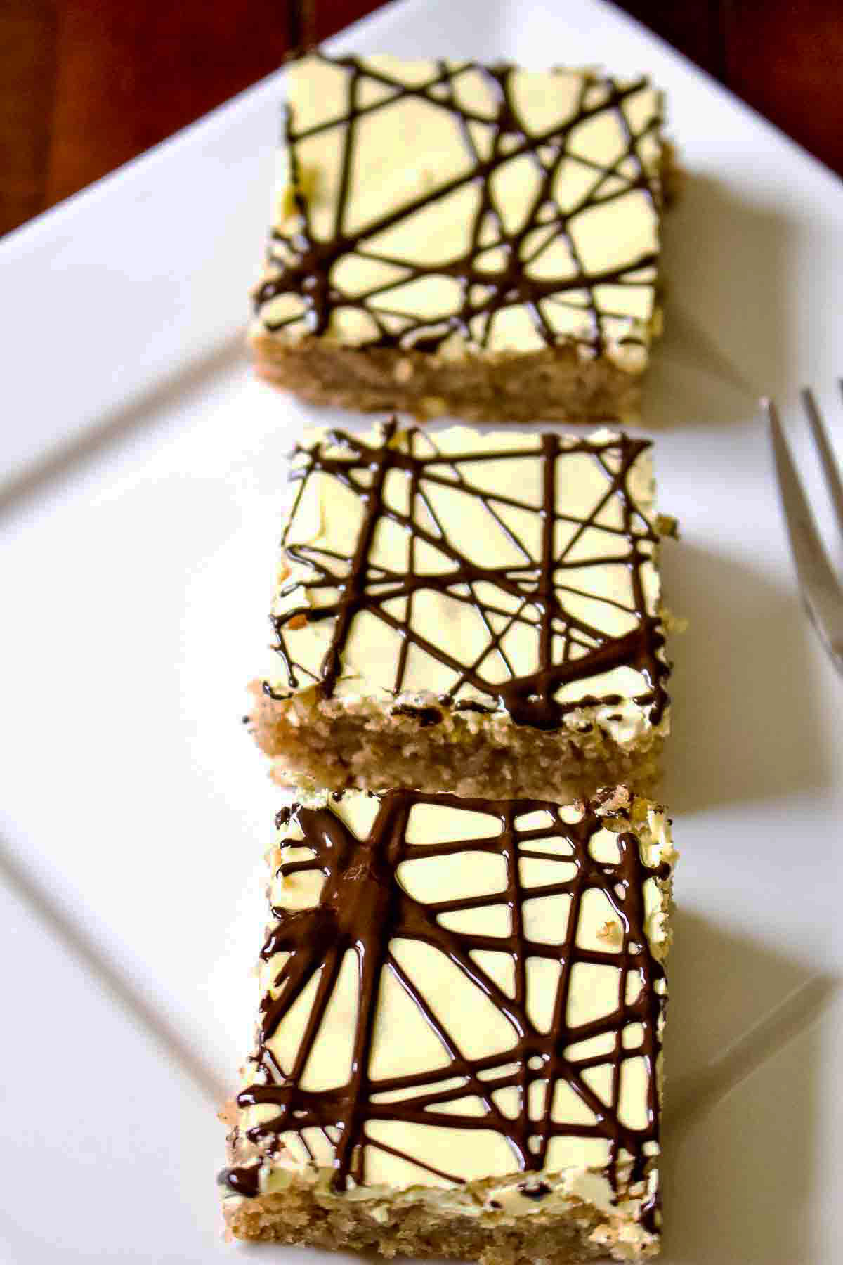 Walnut cake with egg yolk glaze Three Slices Of Walnut Cake With Egg yolk Glaze on white plate.