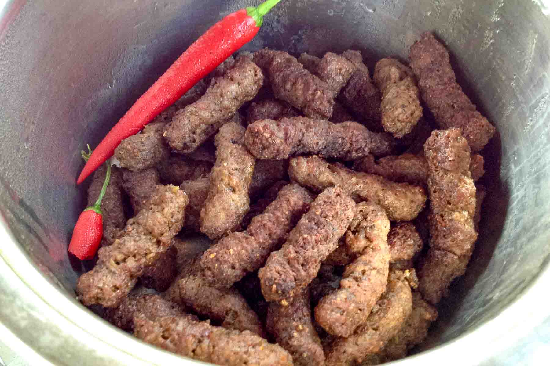 Bowl filled with mititei Romanian grilled sausages.