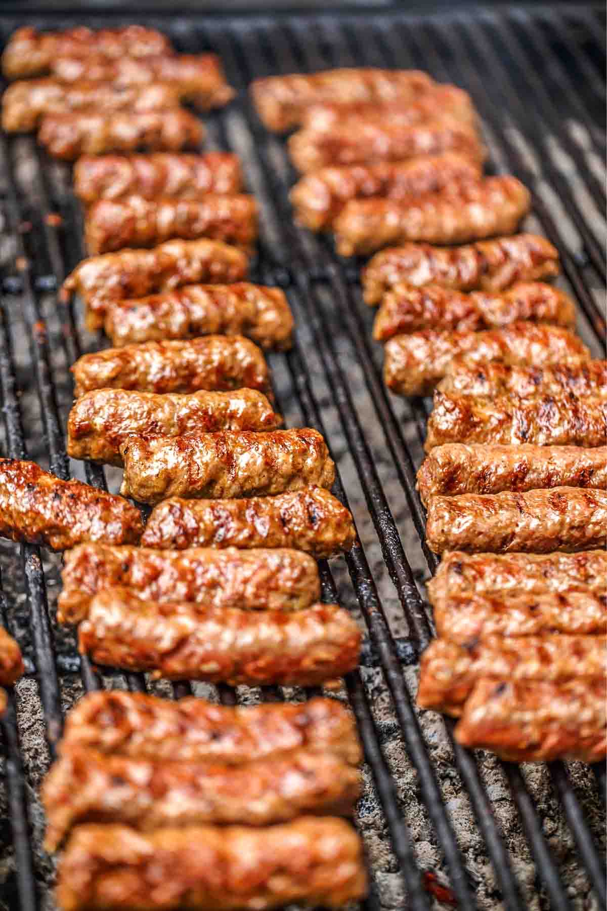 Mititei grilling on a grill.