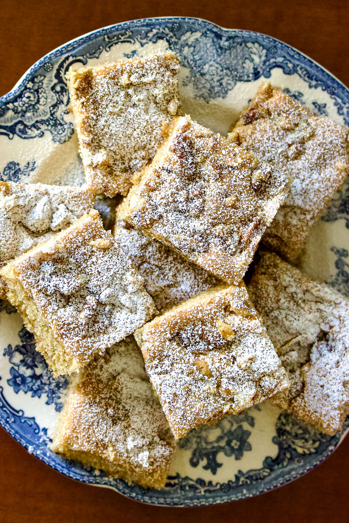 This walnuts and cinnamon coffee cake is an old Saxon recipe coming from Transylvania. My German grandma used to make this recipe very often. The cake is made from a simple batter with butter, sugar, eggs, flour and spices. Before it goes in the oven, the batter is sprinkled with walnuts. Great for breakfast too! Walnut and cinnamon coffee cake slices on a blue and white plate0