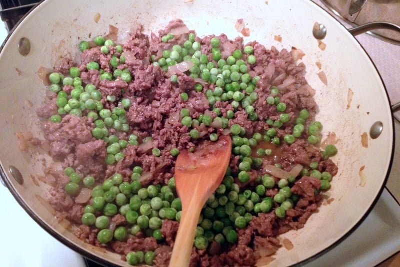 ground meat and peas cooking in a pan