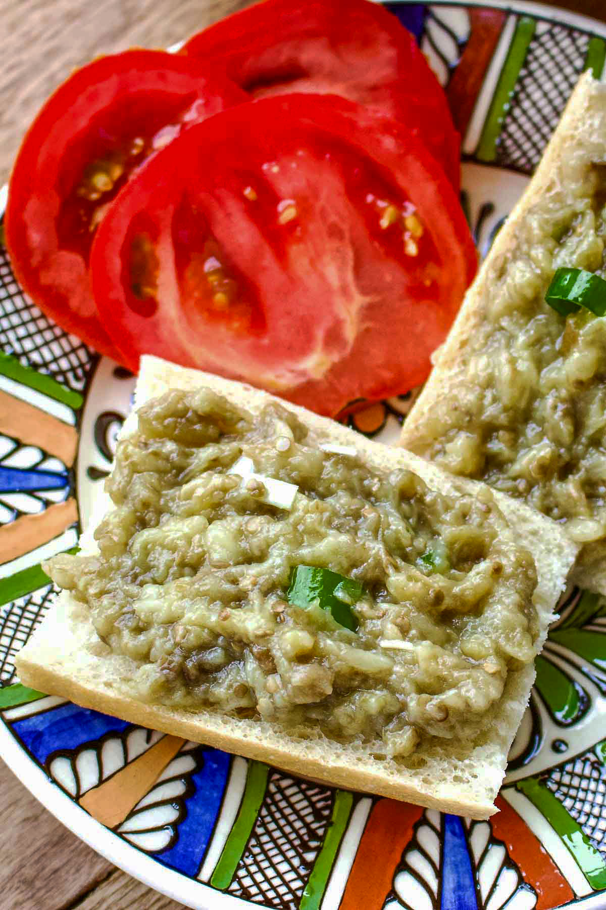 Slices of bread with roasted eggplant salad and tomatoes.