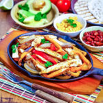 Mexican chicken fajitas with toppings in the background square photo0
