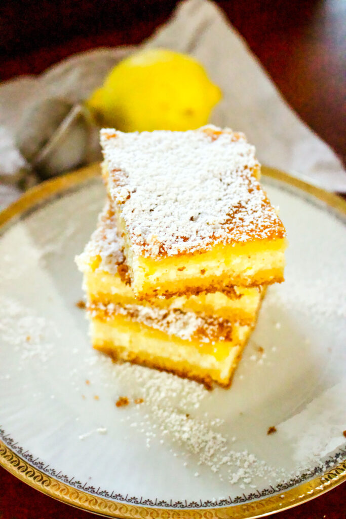 Lemon Ricotta Cheese Cake stacked with lemon in the background0