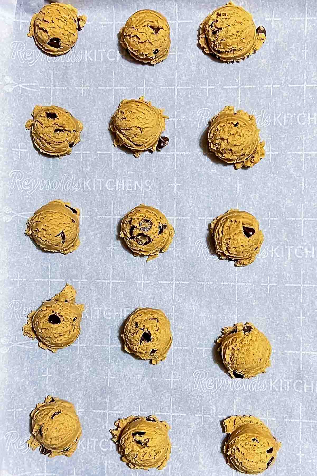 Formed chocolate chip cookies with walnuts ready for baking.