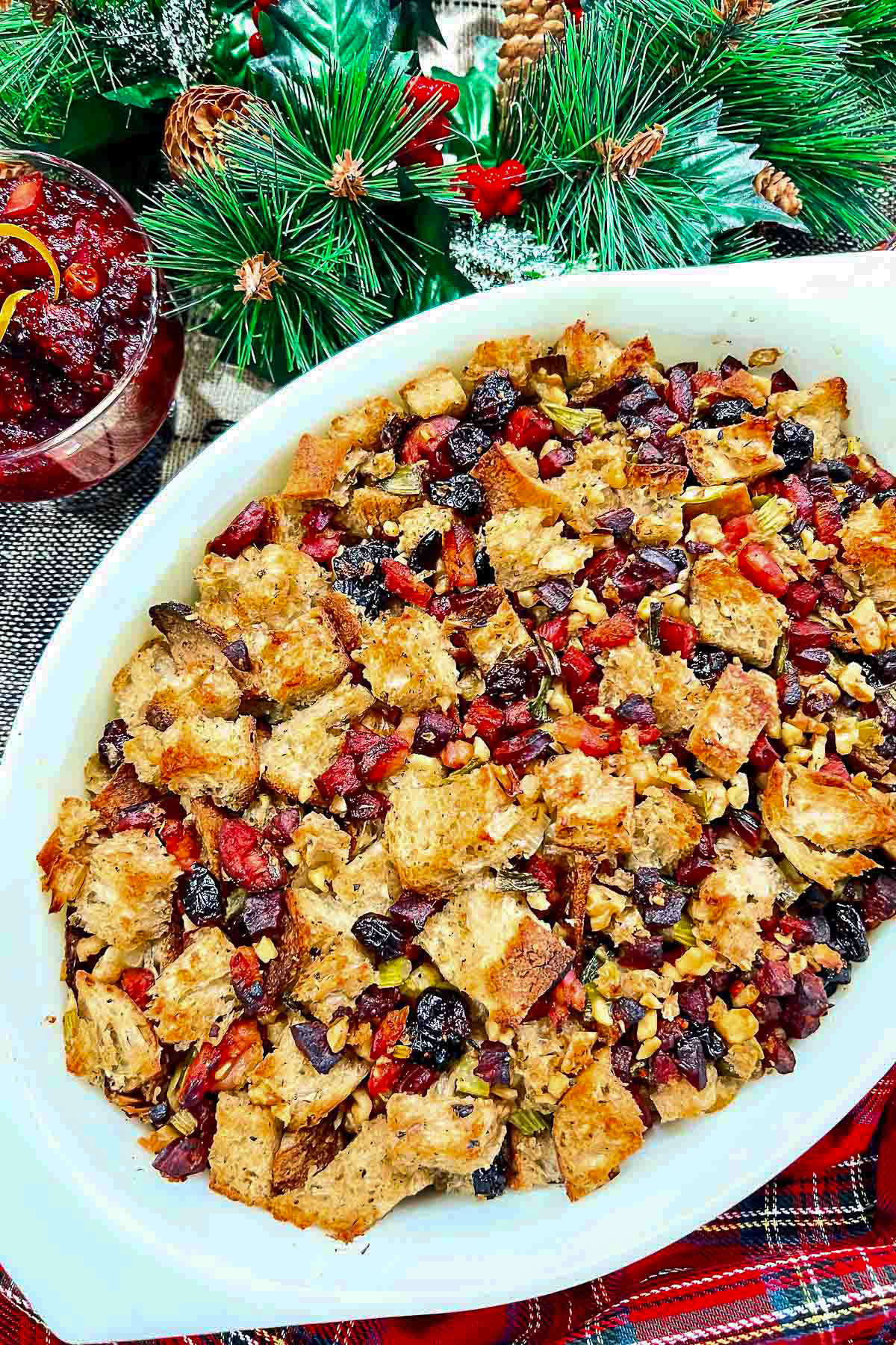 Festive Thanksgiving Stuffing in a baking dish on table with holiday decorations.
