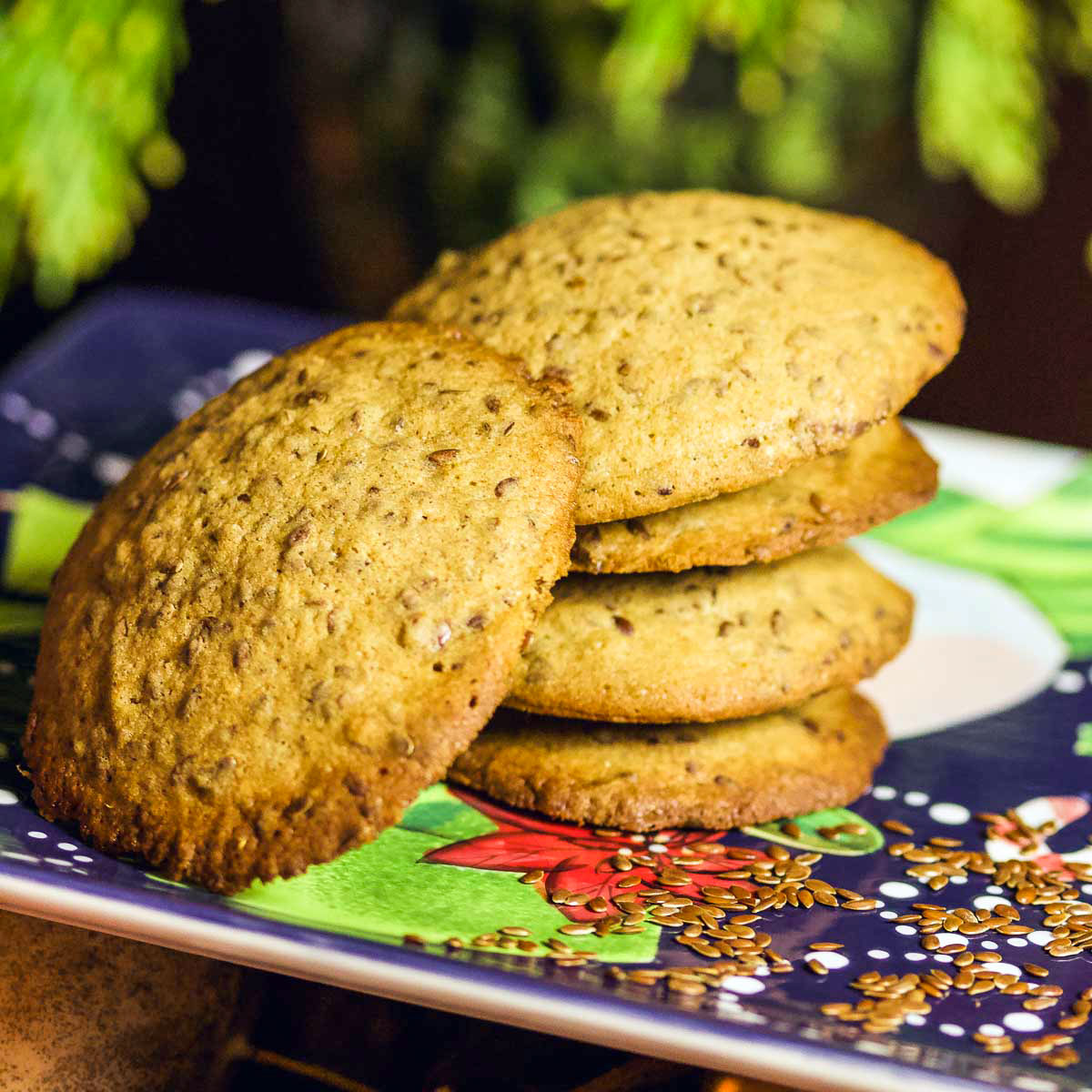 Flaxseed Cinnamon Cookies stacked on a Christmas decorated plate.