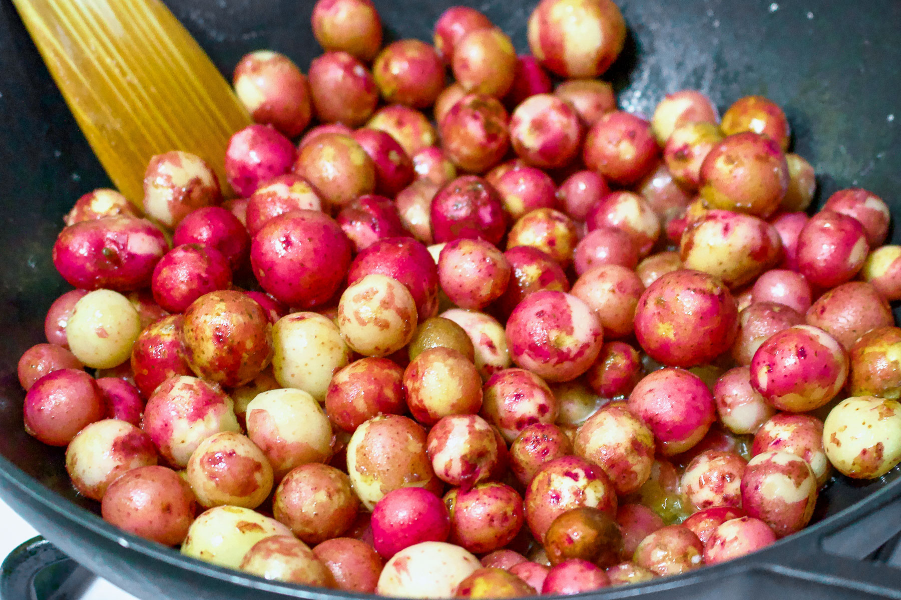 Baby potatoes cooking in a cast iron skillet