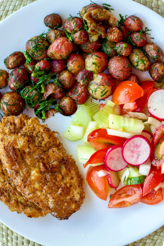 Baby potatoes with chicken schnitzel and salad vertical photo0