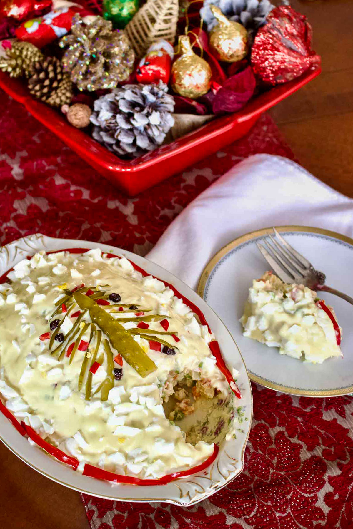 Boeuf Salad on platter with plate and fork sitting on decorated Christmas table.