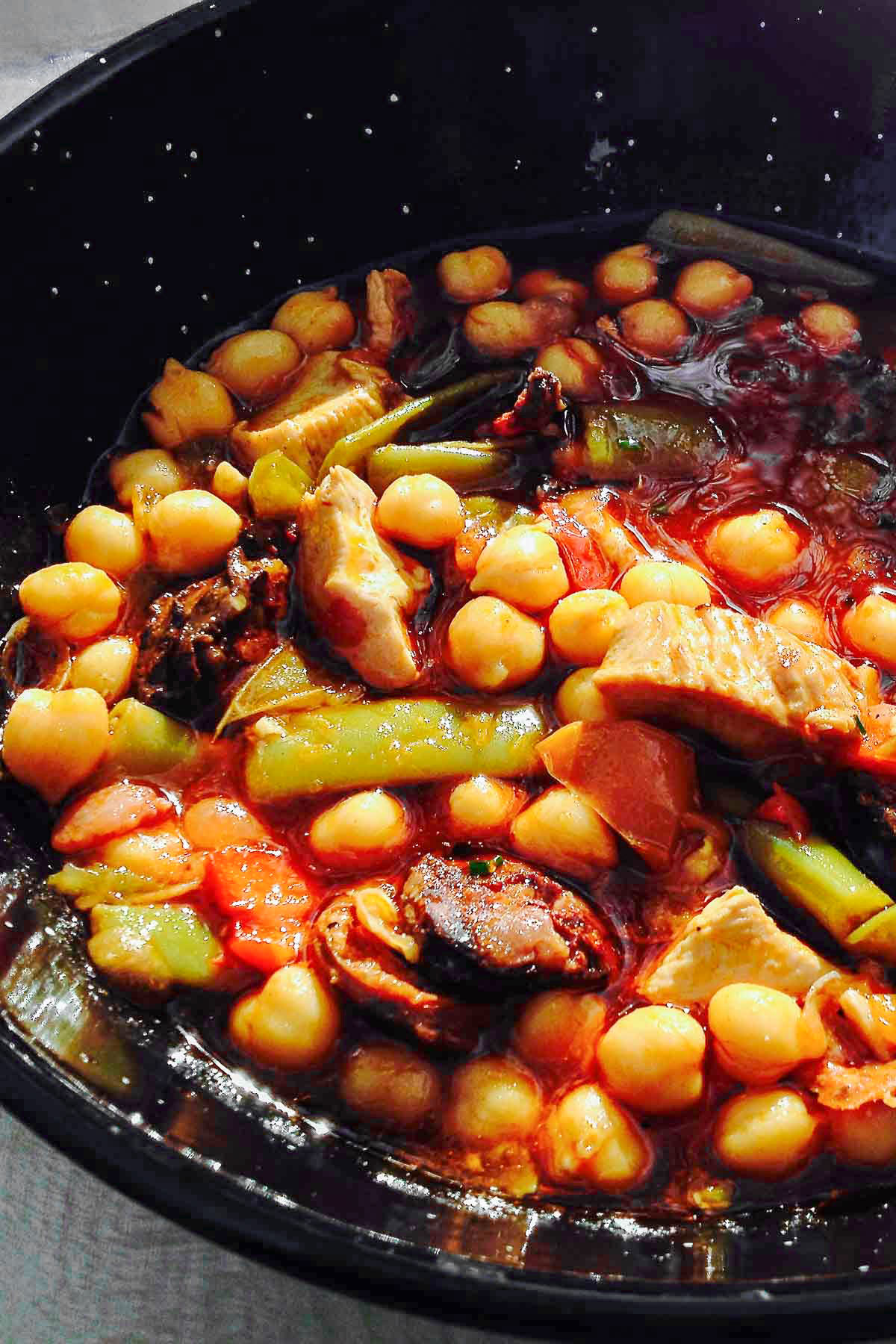 Chickpeas Green Beans With Pork And Spanish Chorizo 1 Chickpea and Green Bean Stew with Pork and Spanish Chorizo in a black bowl.