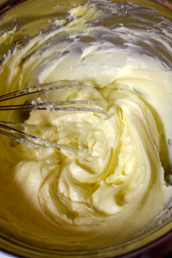 Mixing butter at room temperature with powdered sugar until smooth consistency.