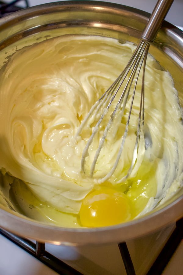 Adding one egg at a time to the butter and sugar.