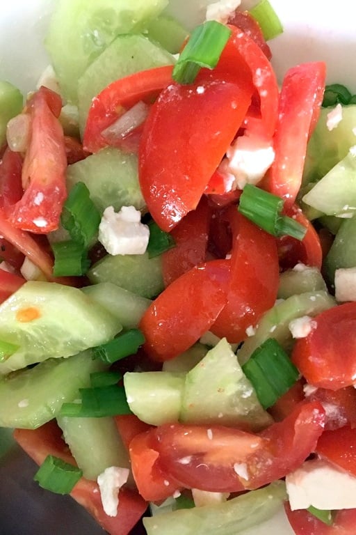 Tomato Cucumbers Feta Salad Recipe is a traditional authentic Romanian salad that can be made all year round. The salad doesn't use vinegar or lemon juice in the dressing, only sunflower oil, salt and pepper. Simple and delicious! Tomato Cucumbers Feta Salad - close up