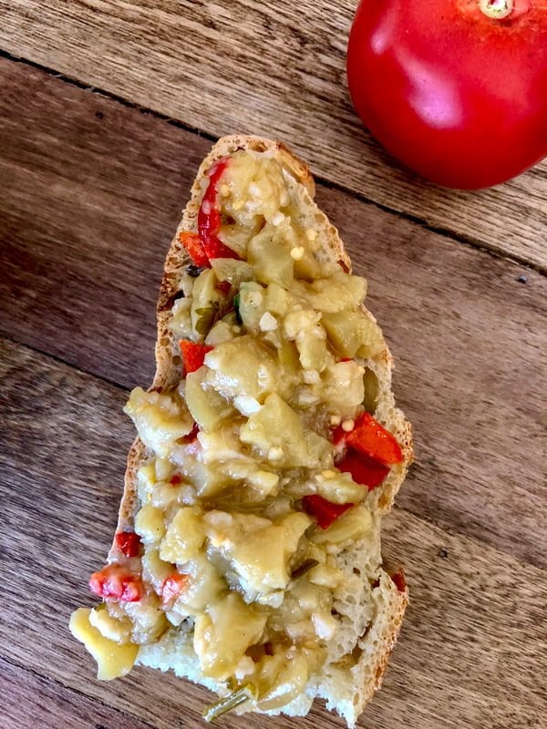 Grilled eggplant and bell pepper salad is a wonderful recipe to make all year long when you have eggplants and peppers available. Perfect as appetizer, or a snack served on slices of good crusty bread, this salad makes a handsome option for entertaining. grilled eggplant with bell pepper salad on a slice of bread