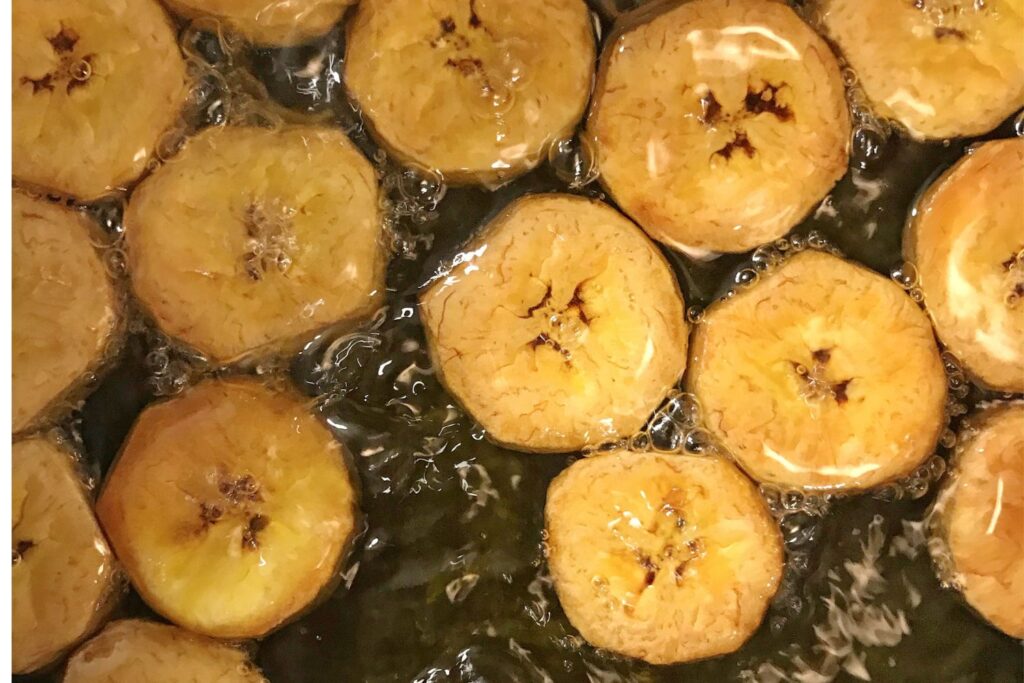 These spiced plantain chips recipe is an easy recipe for a great snack to have around the house. In Latin America, plantains are considered a staple and they can be used either like a potato replacement or made into desserts. This snack has a lovely sweet taste, which is balanced by the chili peppers heat. Delicious! Plantains frying in the pan