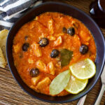 Chicken Stew with black olives and lemons on a black plate0