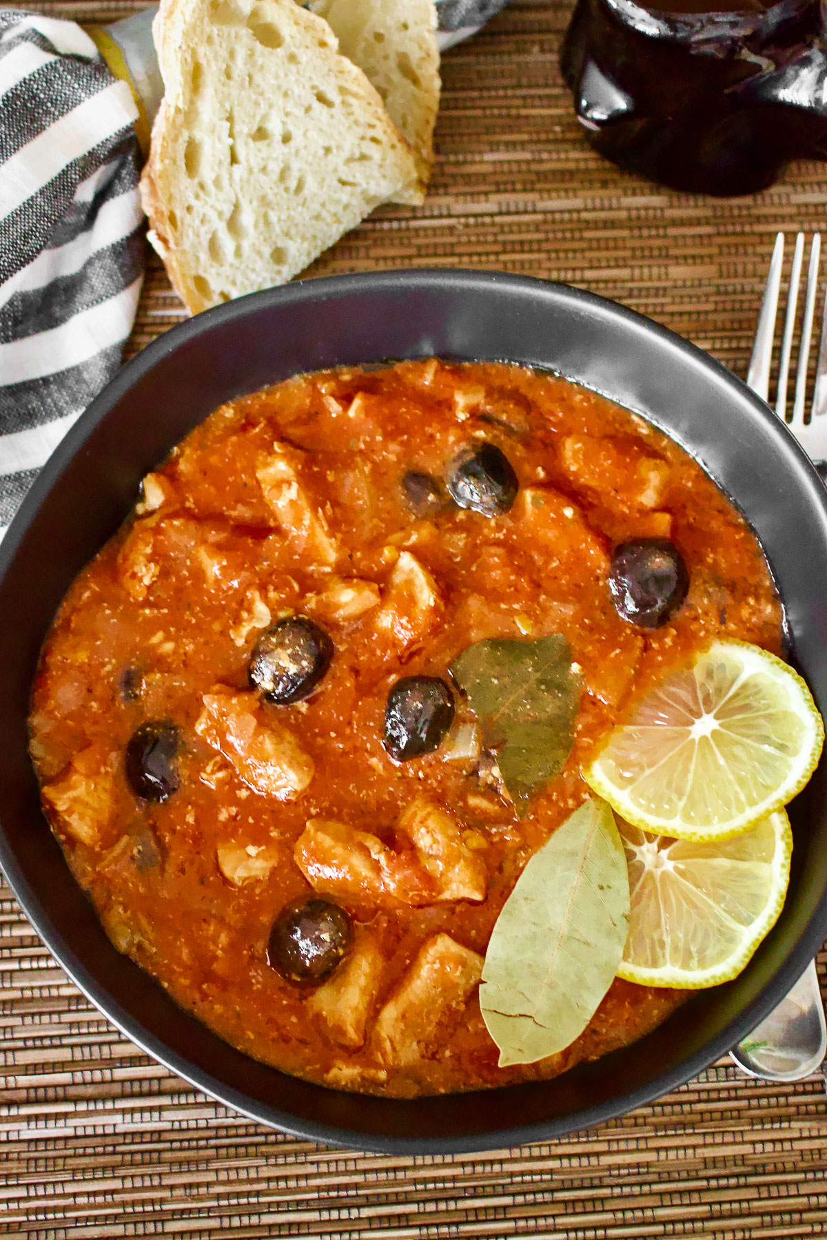Chicken stew with lemons served on black plate with bread0