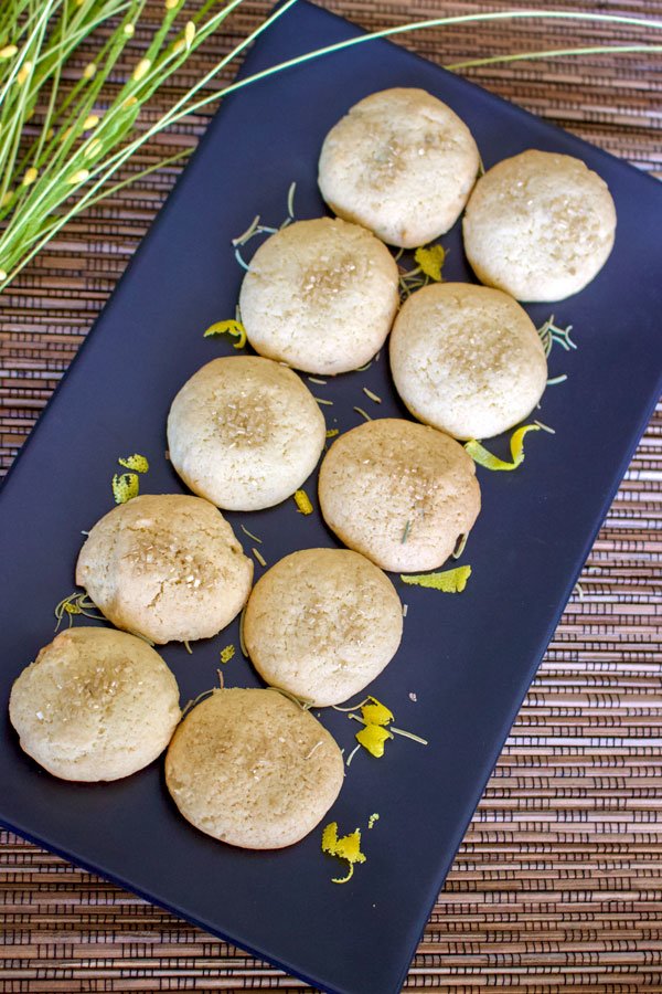 Olive oil lemon cookies with herb- 10 lined up cookies on a black long platter