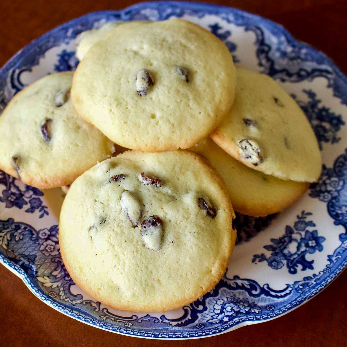 Rum Raisin Cookies stacked on a white and blue plate.